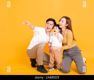 Surprised kid looking away, pointing finger on isolated studio ...