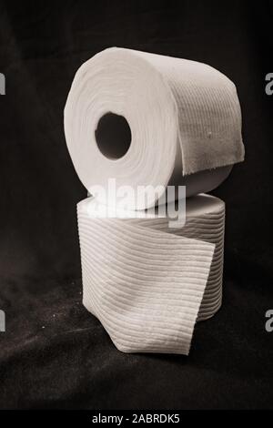 stacked rolls of toilet paper on black background Stock Photo