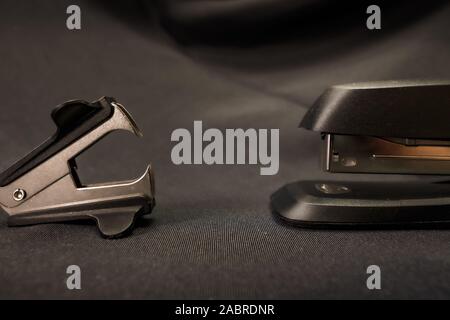 Stapler verses staple remover Office conflict example Stock Photo