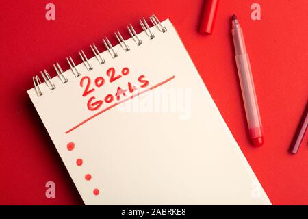 2020 Goals. Creative inscription "2020 Goals" written in white snowflakes on a red background for design. New Year 2020 concept. Stock Photo