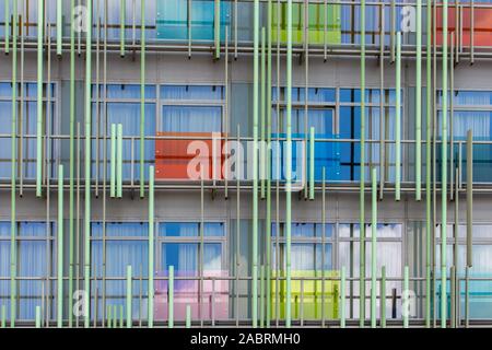 The facade of a modern building, an abstract architectural solution, multi-colored transparent panels and metal tubes in the design of modern housing. Stock Photo