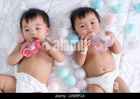 cheerful twin babies on a bed Stock Photo