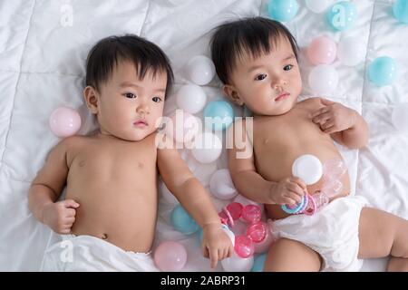 cheerful twin babies on a bed Stock Photo