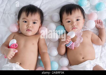 cheerful twin babies on a bed Stock Photo