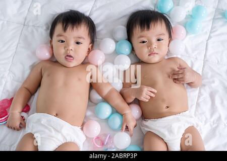 cheerful twin babies on a bed Stock Photo