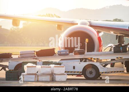process of carrying luggage bag on a conveyor belt to airplane before departure while traveling at the airport Stock Photo