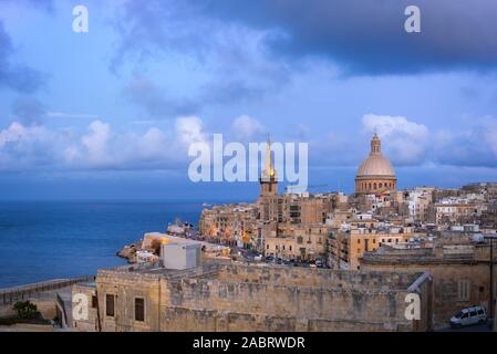 Skyline of Valletta at sunset with Basilica and St. Paul's Anglican Cathedral. Malta Stock Photo