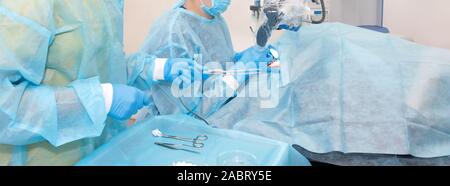 Nurse giving a tool to a doctor during surgery. Hands of doctors during hospital surgery. Ear surgery Stock Photo