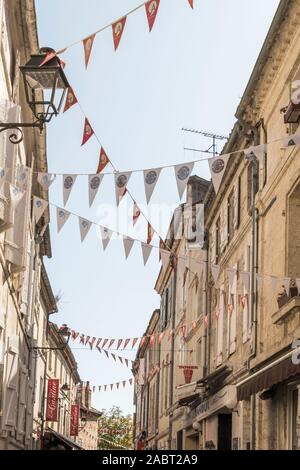 Pretty flags strung between buildings decorates the city of Angouleme in France. Stock Photo