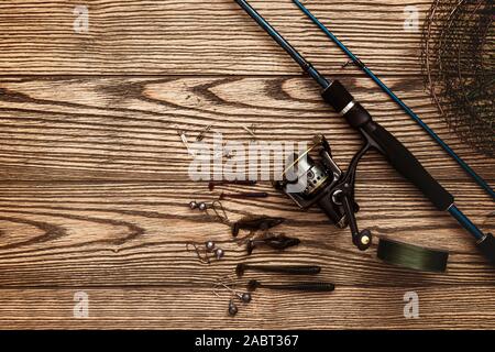 Fishing tackle. Fishing rod, floats, fishing hooks and landing net on old  wooden background with free space for text Stock Photo - Alamy