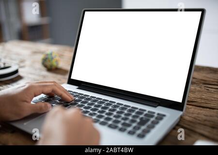 Business Person Using Laptop Computer Showing Blank Screen On Wooden Desk Stock Photo