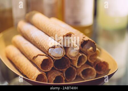 Wafer rolls filled with cream on a plate. Holiday desserts and treats for children. Stock Photo