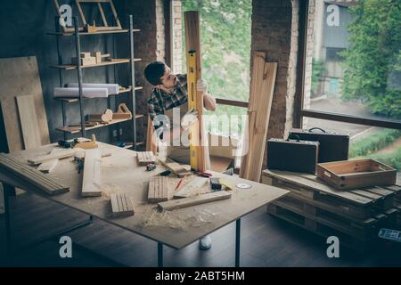 Portrait of his he nice attractive serious concentrated focused experienced skilled hardworking guy checking smoothness board on table desk at modern Stock Photo