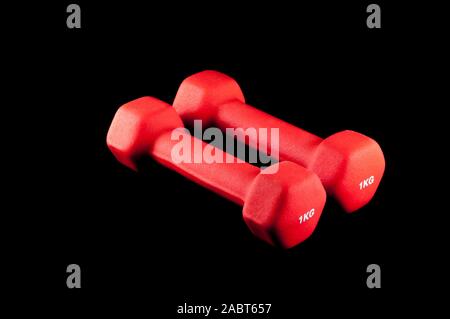 Pair of two red 1 kg dumbbells on black background Stock Photo