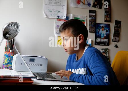 12 Year Old Boy Using A Laptop In His Bedroom In Montrouge