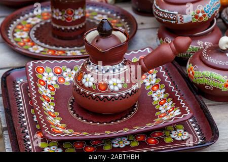 Antique earthenware with beautiful floral pattern on a wooden table Stock Photo