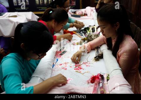 Young female workers doing embroidery.  Hue. Vietnam. Stock Photo