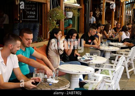 Young Kosovars sitting outside cafes in Gjakova, Kosovo. Stock Photo