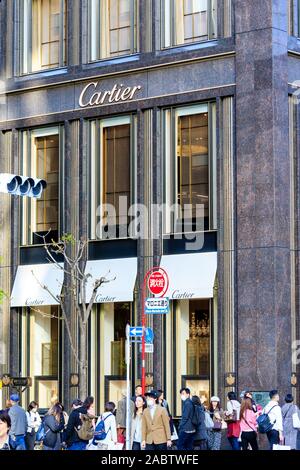 The Boutique Cartier Tokyo Ginza building front with display windows and pavement outside busy and crowded with people. Daytime, springtime. Stock Photo