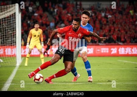 Brazilian-born Portuguese football player Dyego Sousa of Shenzhen F.C., left, protects the ball during the 29th round match of Chinese Football Association Super League (CSL) against Henan Jianye in Shenzhen city, south China's Guangdong province, 27 November 2019. Shenzhen F.C. tied the game with Henan Jianye with 3-3. Stock Photo