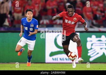 Cameroonian football player John Mary of Shenzhen F.C., right, keeps the ball during the 29th round match of Chinese Football Association Super League (CSL) against Henan Jianye in Shenzhen city, south China's Guangdong province, 27 November 2019. Shenzhen F.C. tied the game with Henan Jianye with 3-3. Stock Photo