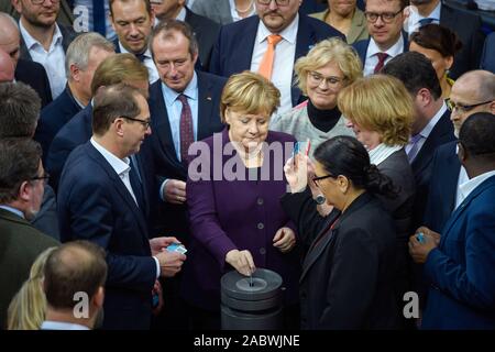 Berlin, Germany. 29th Nov, 2019. Angela Merkel (CDU), Chancellor of the Federal Republic of Germany, will hand in her voting card together with other members of parliament at a ballot box during the 132nd session of the German Bundestag in the plenary hall of the Reichstag building. Credit: Gregor Fischer/dpa/Alamy Live News Stock Photo