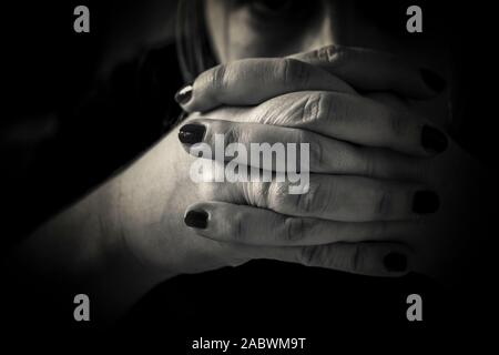 A close-up of woman's hands in prayer in black and white Stock Photo