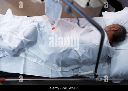 senior man plus year old man recovering from surgery in a hospital bed. Stock Photo