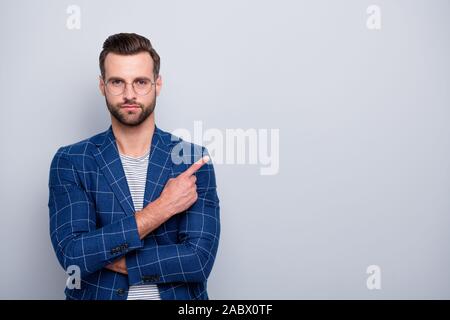 Photo of confident handsome attractive man pointing into empty space wearing spectacles checkered blazer isolated grey color background Stock Photo
