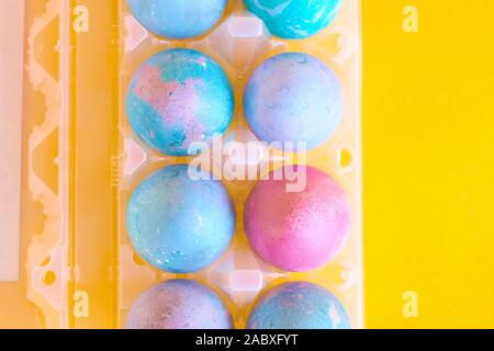 Painted Easter eggs with space intergalactic pattern in stand on yellow background Stock Photo