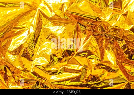 Bright christmas golden background. Shiny yellow gold foil texture. Stock Photo