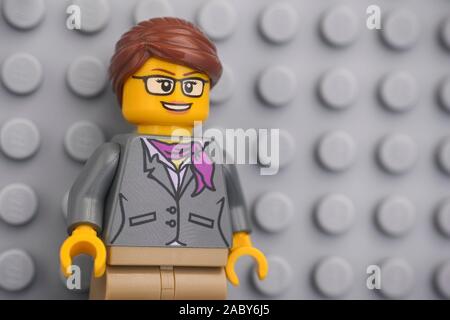 Tambov, Russian Federation - November 08, 2019 Portrait of a Lego businesswoman minifigure standing against lego gray baseplate. Stock Photo