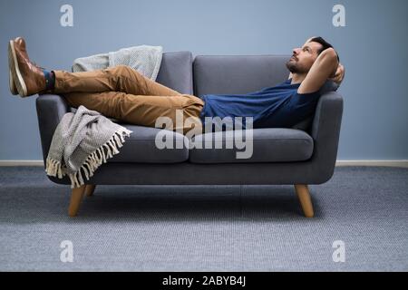 Photo Of Man Relaxing On Sofa At Home Stock Photo