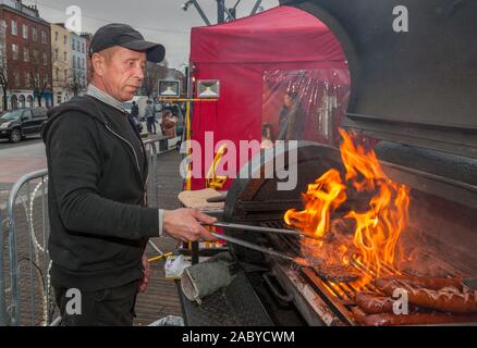 Cork City, Cork, Ireland. 29th November, 2019.  Tadeusk Mielnicki from Blarney, cooking burgers on the BBQ at his stall on the opening day of the annual Glow Festival  on the Grand Parade. GLOW, A Cork Christmas Celebration which  will run every weekend in the build up to Christmas.  Organised by Cork City Council the festival was attended by over 160,000 people in 2019.- Credit; David Creedon / Alamy Live News Stock Photo