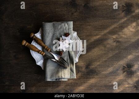 Christmas holiday dinner set decorated with wooden stars and cones on vintage table with copy space Stock Photo