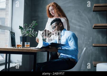Two office workers reading reports and company information in formal clothes Stock Photo