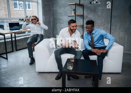 Smiling during the work. Group of multiracial office workers in formal clothes talking about tasks and plans Stock Photo