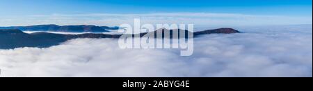 Germany, XXL panoramaaerial  view above endless sea of fog clouds in valley of swabian jura nature landscape on sunny day with blue sky near stuttgart Stock Photo