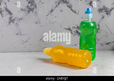 Fresh, fruit fluid for a healthy diet. Isotonic, energy drink. Two bottles with colorful water, a sports drink. Stock Photo