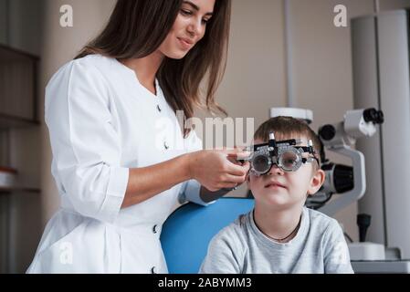 Oftalmolog corrects device. Child sitting in the doctor's cabinet and have tested his visual acuity Stock Photo