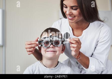 Doctor tuning the phoropter to to determine visual acuity of the little boy Stock Photo