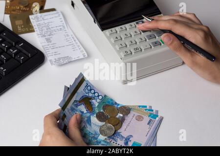 Tenge at the cashier accountant in the hands of the workplace in the office. The cashier counts the money KZT in the workplace in Kazakhstan. Salary i