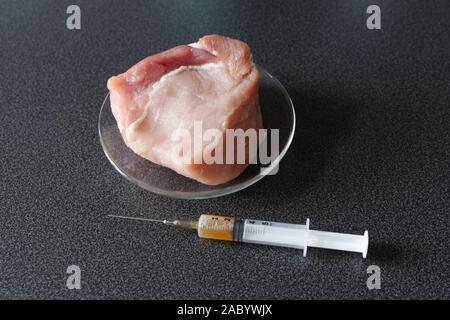 Researcher injecting GMO a slice of pork meat. Genetically modified organism, harmful for peples health. Meat with antibiotics concept. Stock Photo