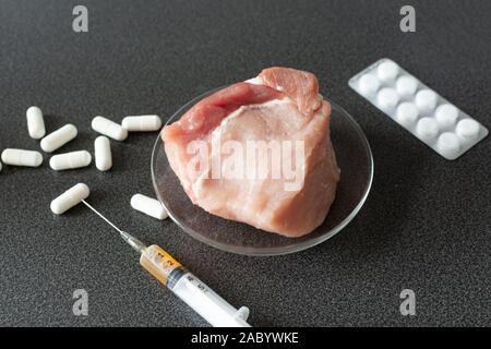 Researcher injecting GMO a slice of pork meat. Genetically modified organism, harmful for peples health. Meat with antibiotics concept. Stock Photo