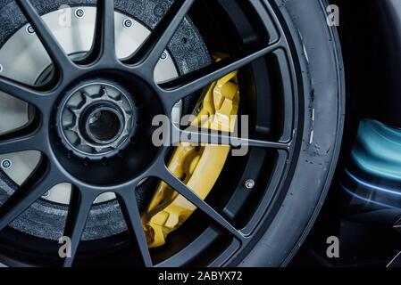 Close up shot of black light alloy wheels with yellow brake disc pad, low-profile tires of a car Stock Photo