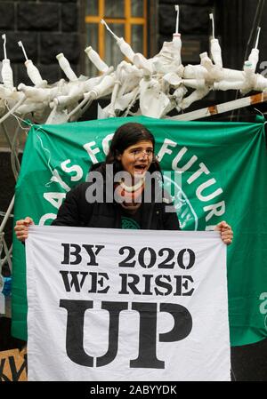 An activist shouts slogans while holding a banner that says by 2020 we rise up during the Global climate strike.This is the fourth global strike in 2019, which takes place as part of the weekly demonstrations of the Fridays for Future youth movement around the world. 'Ahead of the UN COP25 Climate Change Conference in Madrid 2-13 December, the European Parliament on Thursday, approved a resolution declaring a climate and environmental emergency in Europe and globally', a press release of the European Parliament informed on November 28, 2019. Stock Photo
