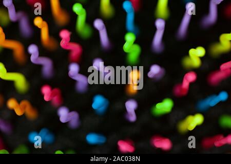 Abstract background of colorful waves in motion on black. Bokeh of defocused curves, blurred neon blue, yellow and red leds, imitation of glowing sper Stock Photo
