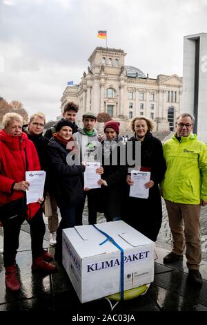 29 November 2019, Berlin: Ulli Nissen (SPD, l-r), Lorenz Gösta Beutin (Die Linke), both members of the German Bundestag, Katja Kipping, Federal Chairwoman of Die Linke, Hannes Jung, Fabian Gacon, both members of the BUNDjugend Executive Committee, Cecilia Bösche of the BUNDjugend, Sylvia Kotting-Uhl (Bündnis 90/Die Grünen), Member of the German Bundestag, and Olaf Bandt, Chairman of the German Association for the Environment and Nature Conservation (BUND), are standing in front of the Reichstag building after a bathing action by activists of the BUND youth against the climate package of the Ge Stock Photo