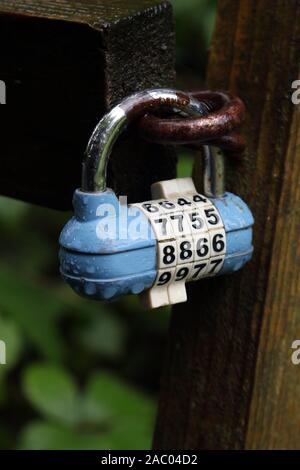 A blue combination padlock on an outside gate Stock Photo