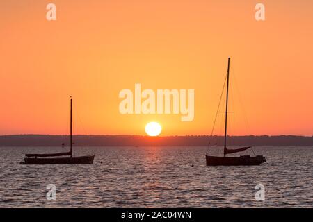 Two Auswanderers, traditional wooden sailing boats in Steinhuder Meer / Lake Steinhude silhouetted against sunset, Lower Saxony / Niedersachsen, Germa Stock Photo